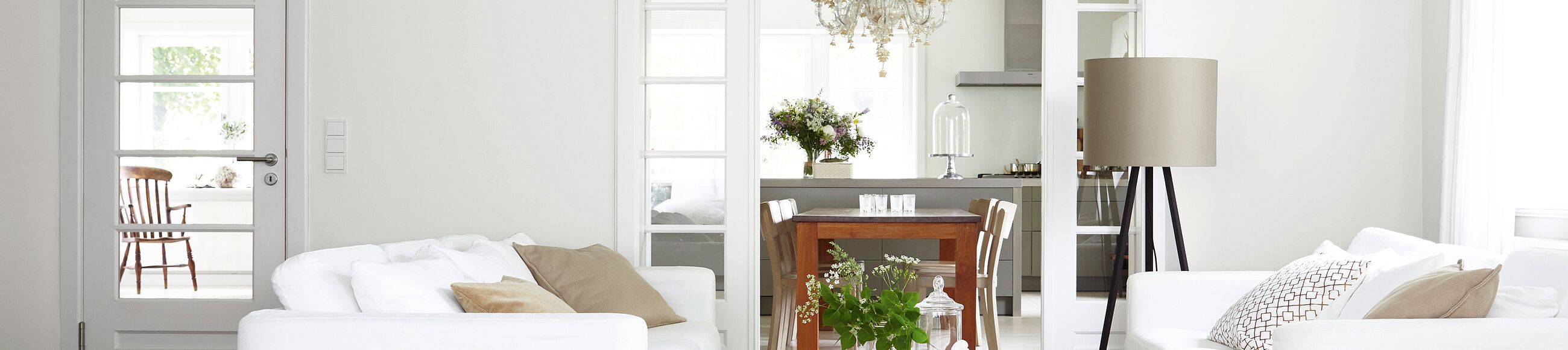 Ein Wohnzimmer mit weißen Wänden und zwei weißen Sofas