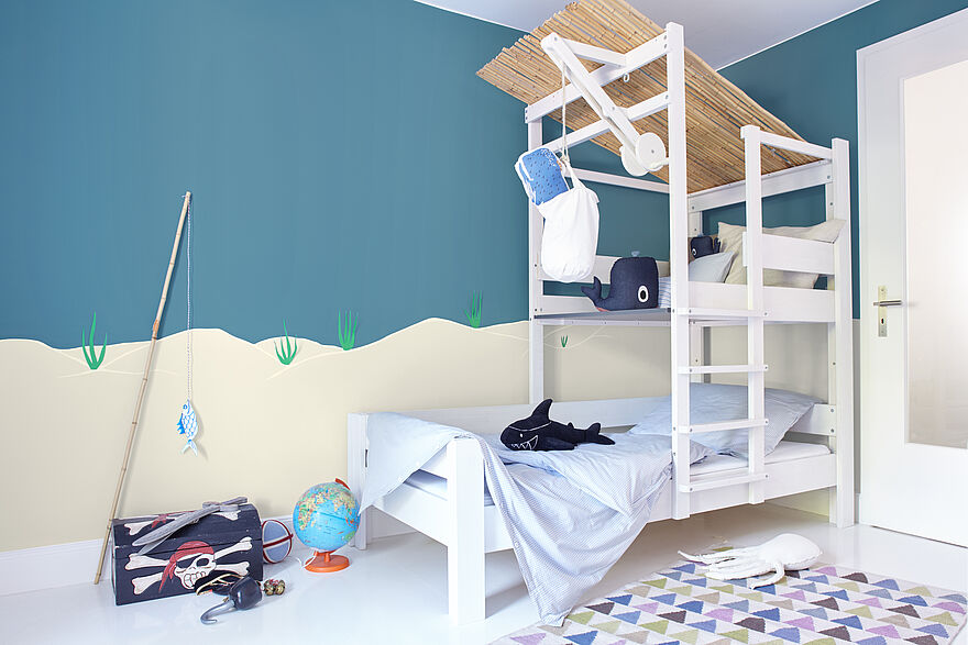 Modernes Jungen Kinderzimmer in weiß und blau mit Fisch und Piraten Thema mit Alpina Farbenfreunde Farbe Seebärblau.