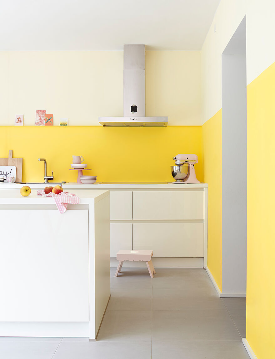 Helle, moderne, weiße Küche mit heller gelber Wand.