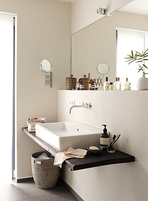 Waschtisch in einem Badezimmer vor einer Wand in Beige.
